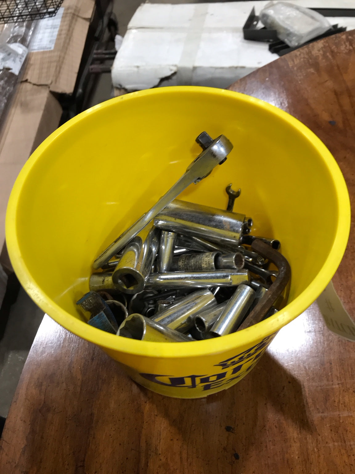 Assorted Ratchets, Sockets, and Tools in a Yellow Bucket