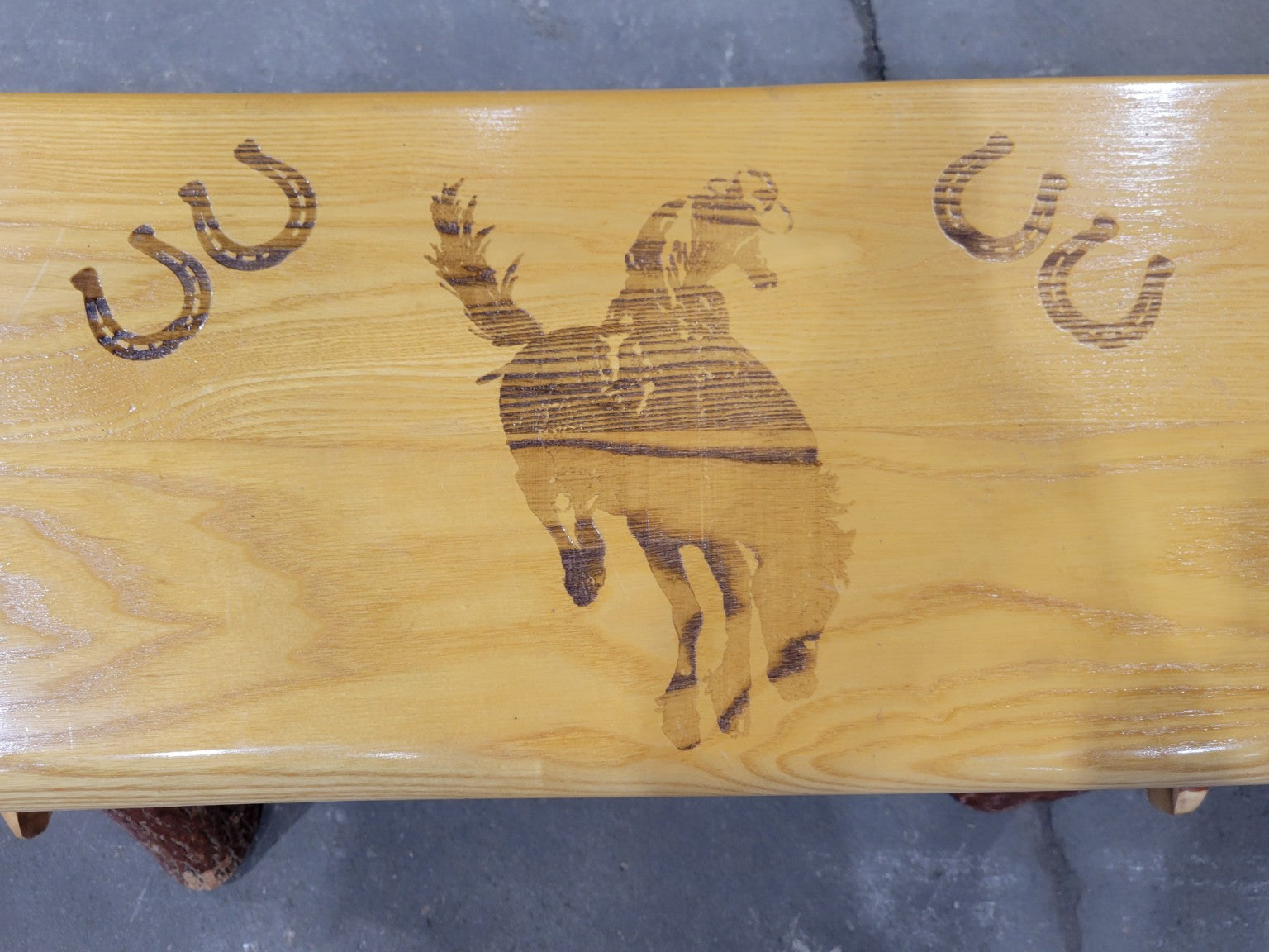 Rustic Log Bench with Bucking Horse Motif